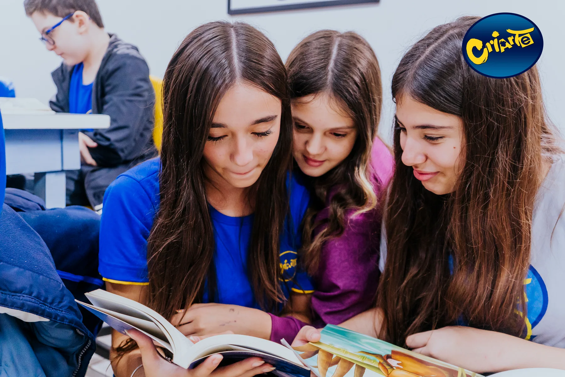 Alunas uniformizadas da Escola Criarte lendo juntas na biblioteca