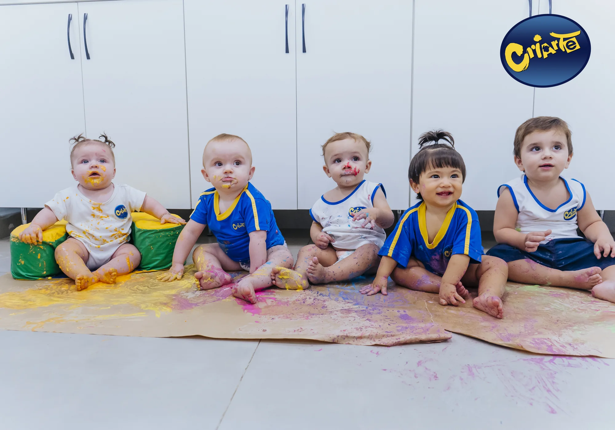 Bebês da Escola Criarte em atividade sensorial com tintas